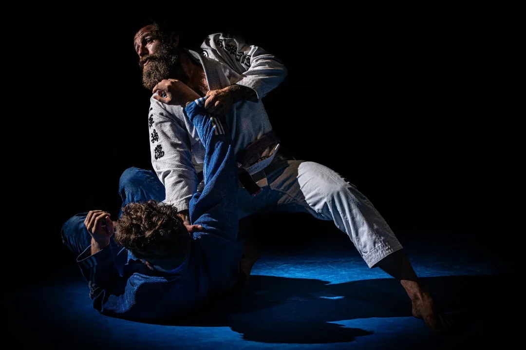 Advanced Brazilian Jiu-Jitsu training under controlled lighting.